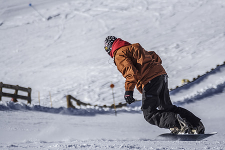 person wearing brown snowsuit and riding snowboard at daytime thumbnail