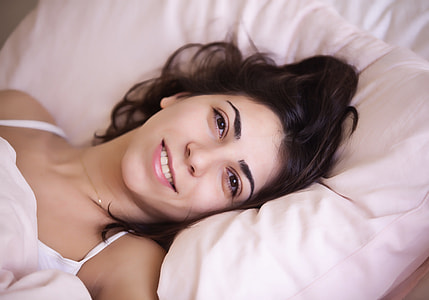 woman lying on bed wearing white spaghetti-strap top thumbnail