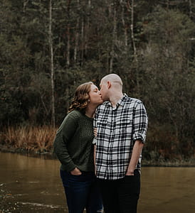 couple kissing on body of water during daytime thumbnail
