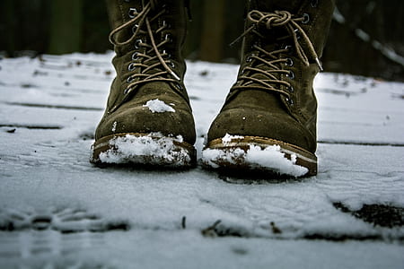 selective focus photography of work boots on snow field thumbnail