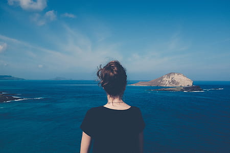 woman wearing black top facing sea during daytime thumbnail
