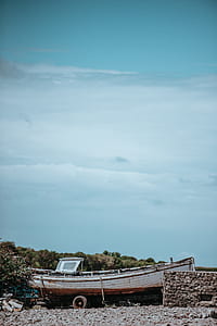 white boat on boat trailer under cloudy blue sky thumbnail
