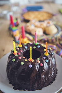chocolate cake with five candles on white ceramic plate thumbnail