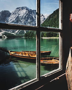 photography of brown wooden kayaks docked beside wooden house at daytime thumbnail
