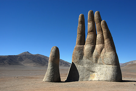brown concrete hand figure at field dessert at daytime thumbnail