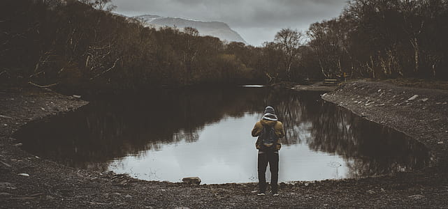 man standing in front of the body of water thumbnail
