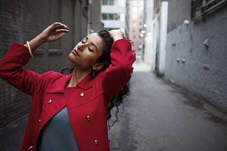 Woman in Red Coat Between Gray Concrete Walls thumbnail