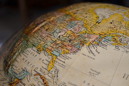 tilt shift lens photography of brown and white desk globe thumbnail