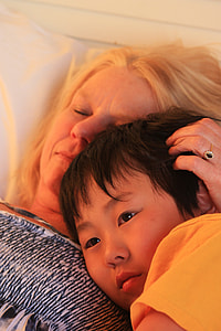 woman and boy lying on bed thumbnail