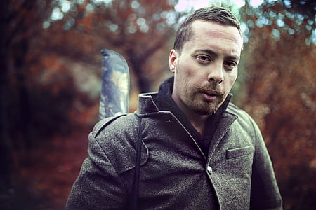 Man Wearing Gray Jacket in Front of Trees thumbnail