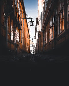 photo of pathway beside brown buildings during daytime thumbnail