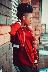 Woman Holding Her Neck While Standing Beside Wall thumbnail