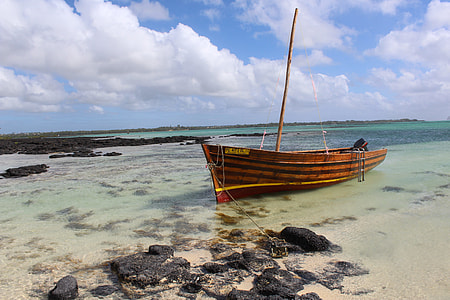 brown wooden boat near on seashore thumbnail