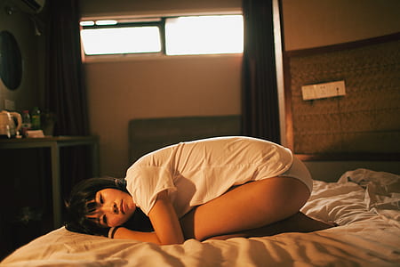 woman in white shirt kneeling on mattress thumbnail