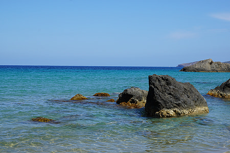black rock formation on calm sea water at daytime thumbnail