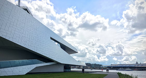 white painted building under cumulonimbus clouds thumbnail