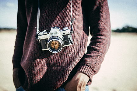photo of person with gray and black MILC camera with sling thumbnail