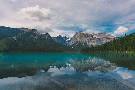 body of water surrounded by trees near mountain range thumbnail