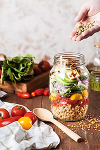 person putting vegetable slices on glass jar thumbnail