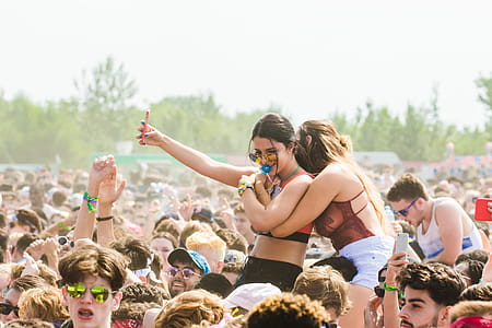 Two Women Embracing Surrounded by Crowd thumbnail
