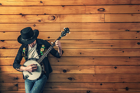 man playing a banjo leaning on the wall thumbnail