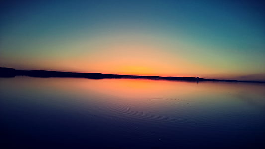 sunset reflecting on body of water thumbnail