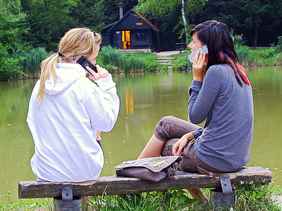 two woman sitting on bench while calling thumbnail