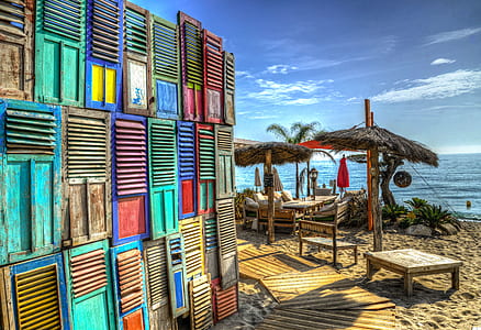 multicolored wooden louvres made into wall near body of water taken during daytime thumbnail