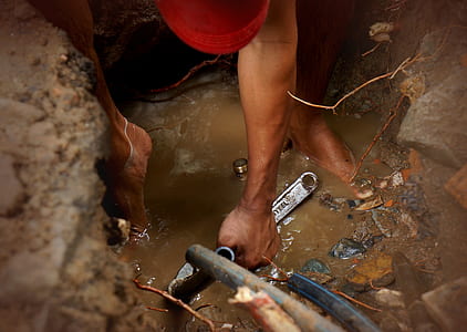 person holding wrench on swamp during daytime thumbnail