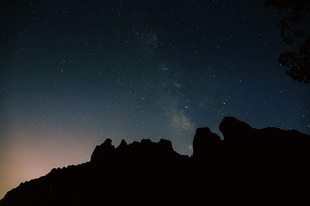 silhouette photography of mountain under starry nighjt thumbnail