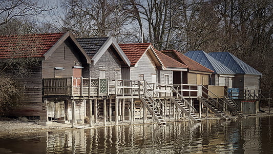 wooden houses beside body of water thumbnail