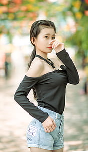 woman wearing black off-shoulder long-sleeved top and blue denim short shorts thumbnail