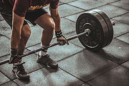 man lifting black steel barbell thumbnail
