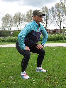 person squatting on green grass field thumbnail