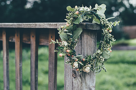 magical pumpkin and white rose flower wreath hangs on brown wooden rail thumbnail