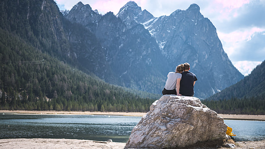 man and woman sitting on top of big rock thumbnail