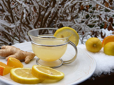 clear glass teacup with yellow substance on top of white plate thumbnail