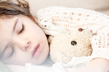 girl sleeping beside grey teddy bear thumbnail