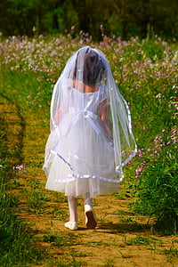 child wearing white dress walking surrounded with pink petaled flower thumbnail
