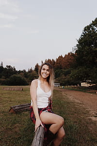 woman sitting on brown fence thumbnail