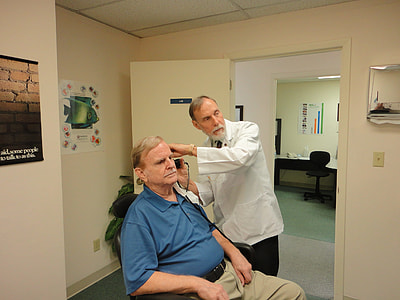 man in blue polo shirt sits while having a haircut thumbnail
