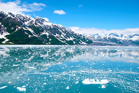 mountain surrounded by snow beside body of water thumbnail