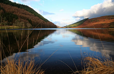 body of water surrounded by mountains during daytime low angle photography thumbnail