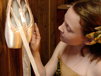 woman wearing brown tube dress holding pair of brown velvet ballet flats thumbnail