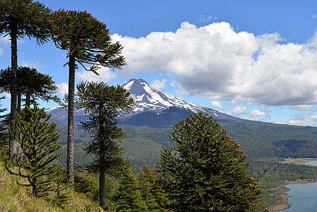 mountain near body of water under white clouds thumbnail