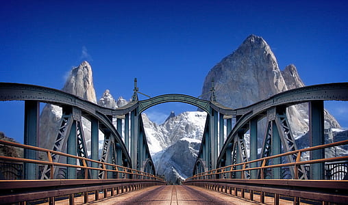 photo of gray metal bridge near mountain thumbnail