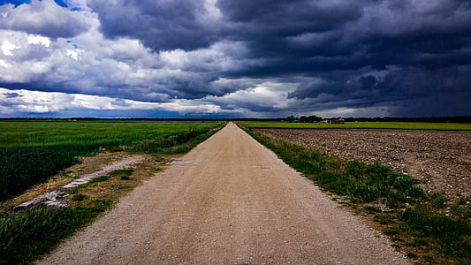 Dirt Road Surrounded With Green Field Under Cloudy Sky thumbnail