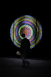 man walking in front of multicolored neon sign thumbnail