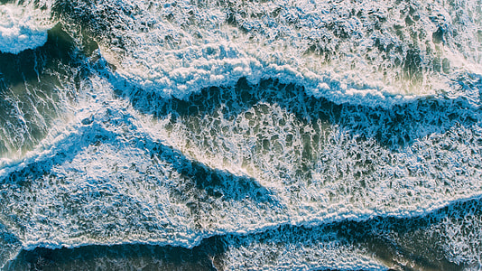 closeup photo of water rushing in to the shoreline thumbnail