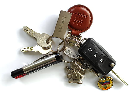 gray and black key with keychain on white surface thumbnail